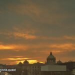 Prague skyline at sunset with dome in the distance by Peter Wynne