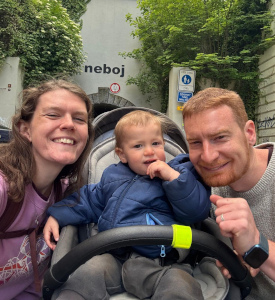 baby in stroller with parents at the Prague pedestrian tunnel on the Karlin side with the word 'Neboj' over the entrance.